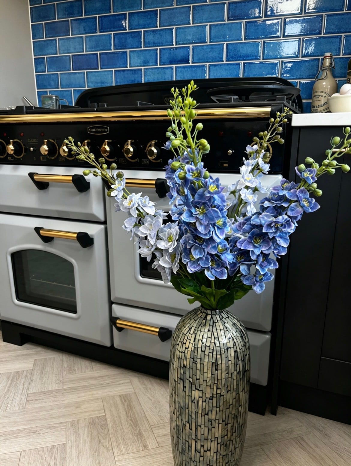 Azure Dream blue and white artificial bouquet displayed in a tall patterned vase; vase shown for display only