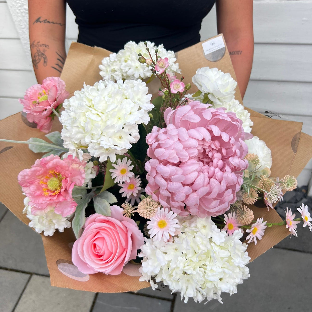Blush Romance artificial bouquet with pink and ivory blooms held in its presentation wrapping