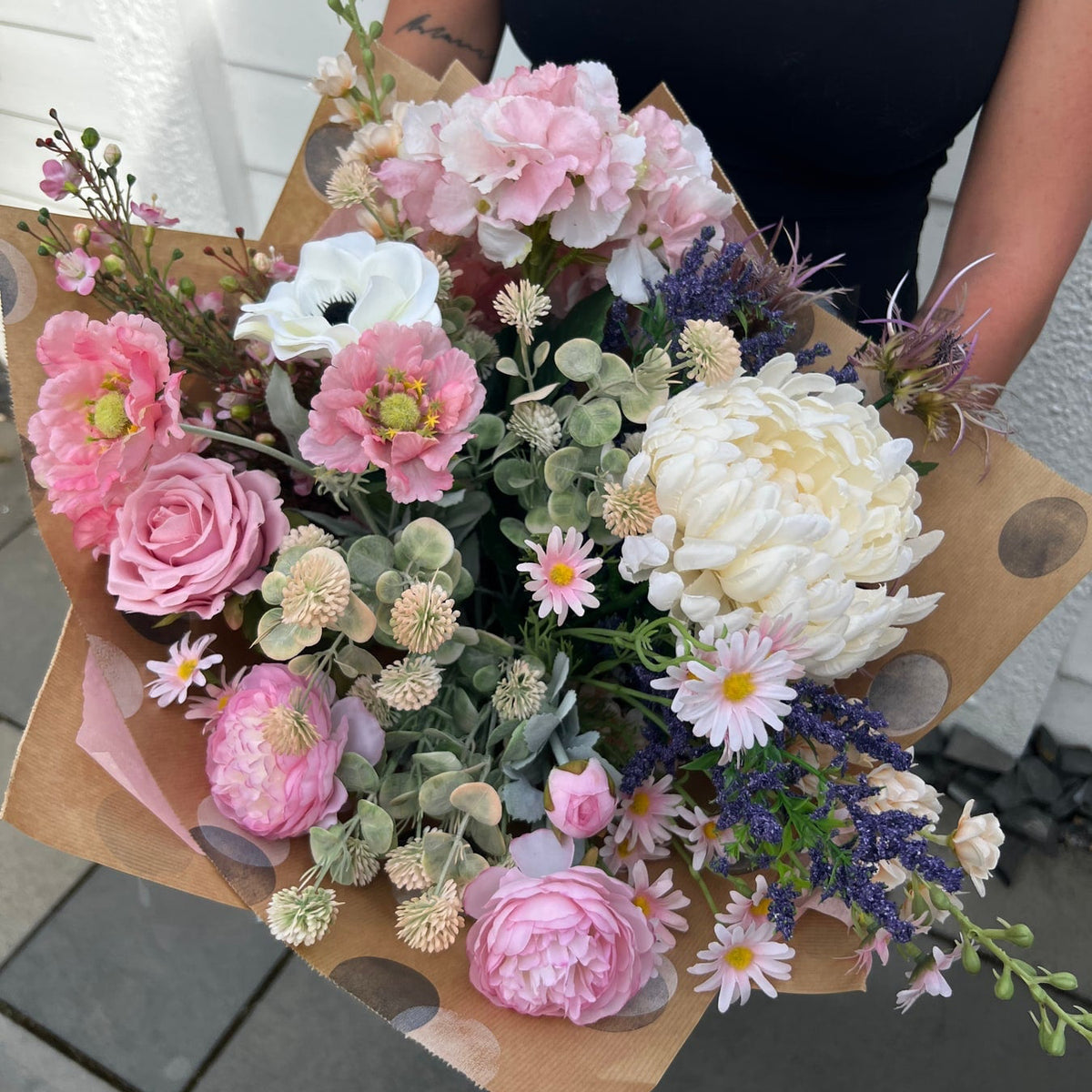 The Cottage Garden artificial bouquet with pink, ivory and purple flowers held in kraft presentation wrapping
